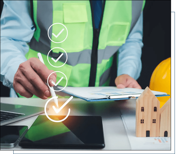 Person in safety vest working with documents and home model.