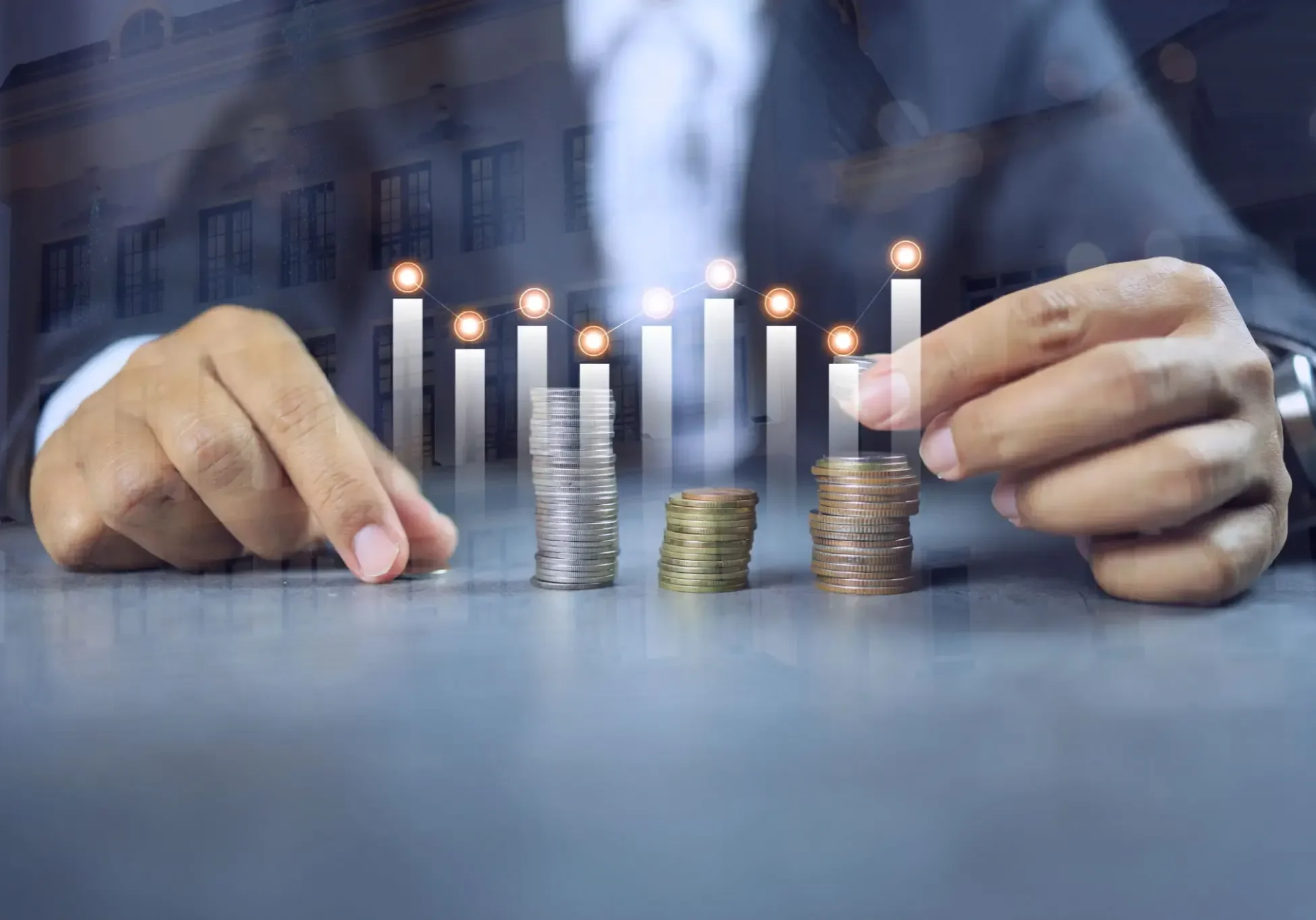 Hands stacking coins under lit candles symbolizing financial growth and planning.